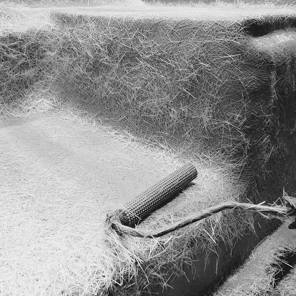 Processus de fabrication de piscines en coque avec renforcement en fibres et utilisation d'un rouleau de finition dans un environnement professionnel